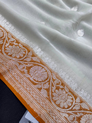 Woman wearing a Pure Khaddi Chiffon Saree with zari border and flowing drape – ideal for weddings and festive occasions.