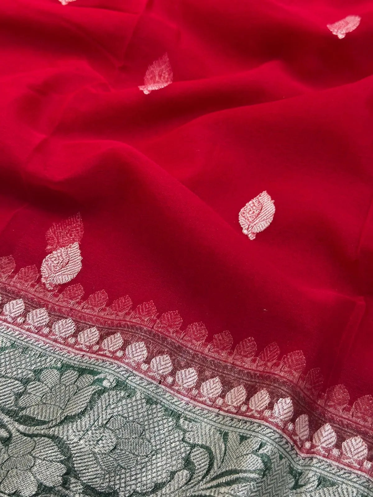 Woman wearing a Pure Khaddi Chiffon Saree with sheer, lightweight fabric and zari details, ideal for weddings and festive occasions.