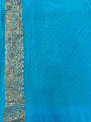 Woman draped in a Pure Khaddi Georgette Saree with intricate zari work and soft flowing texture, perfect for traditional functions and weddings.