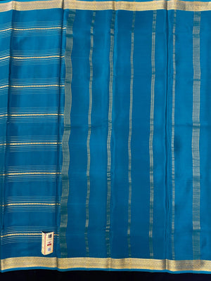 Woman wearing a Pure Mysore Silk Saree with smooth drape and zari border, perfect for weddings and traditional South Indian events.
