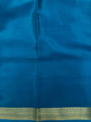 Woman wearing a Pure Mysore Silk Saree with smooth drape and zari border, perfect for weddings and traditional South Indian events.