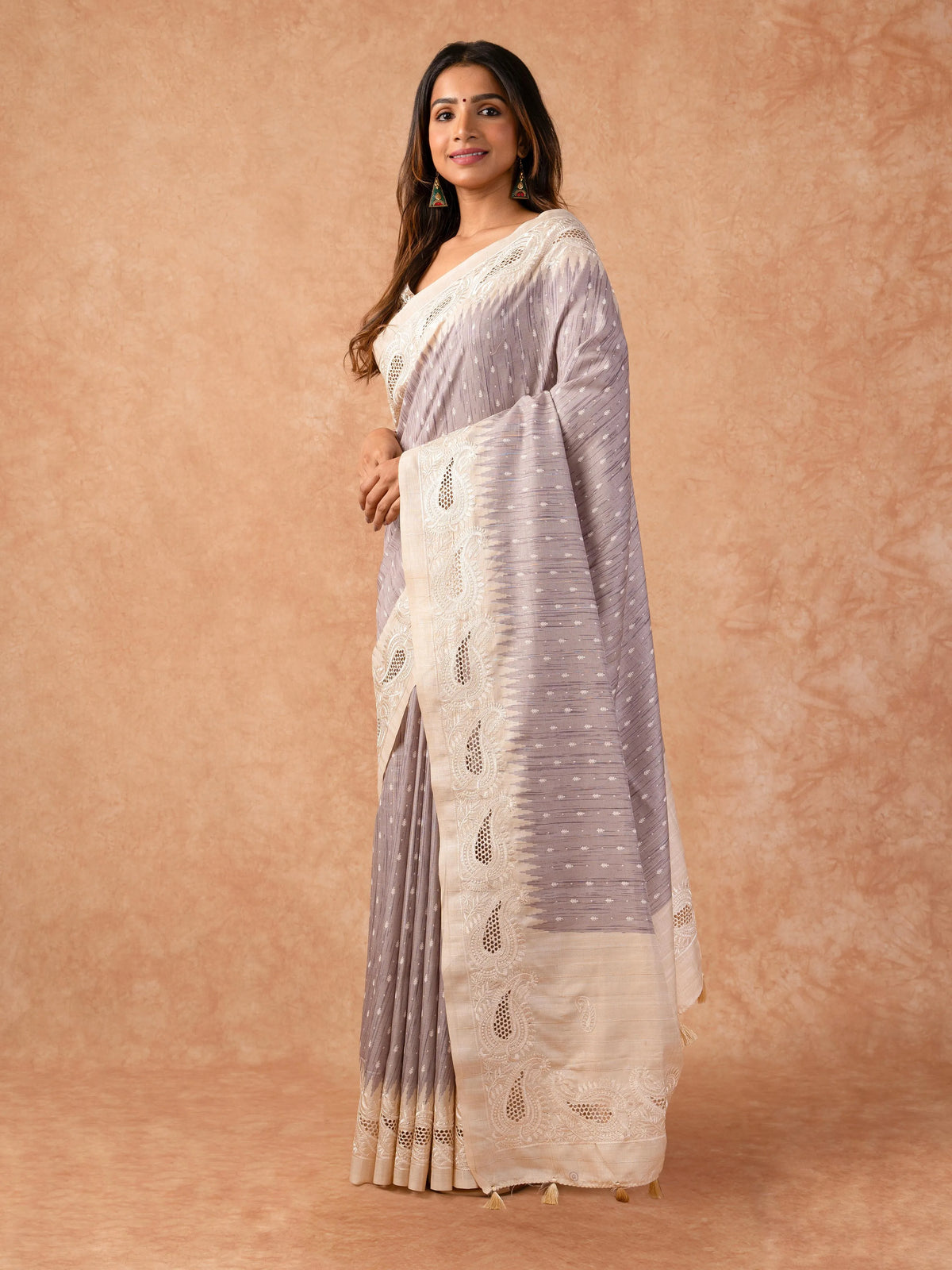 Woman wearing a Milky Cutwork Tussar Silk Saree with delicate embroidery and soft drape, ideal for weddings, receptions, and festive occasions.