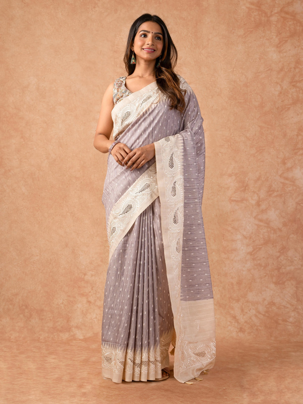 Woman wearing a Milky Cutwork Tussar Silk Saree with delicate embroidery and soft drape, ideal for weddings, receptions, and festive occasions.