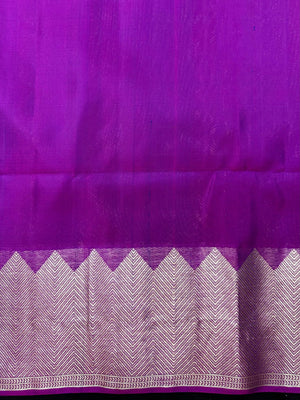 Woman draped in a Pure Kanjivaram Silk Saree with rich silk texture, vibrant colors, and traditional zari border, ideal for weddings and festivals.
