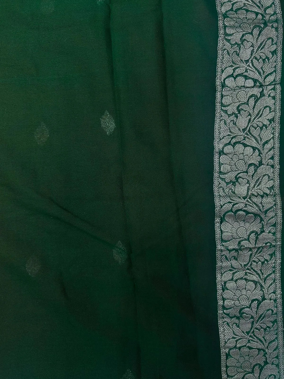 Woman wearing a Pure Khaddi Chiffon Saree with sheer, lightweight fabric and zari details, ideal for weddings and festive occasions.
