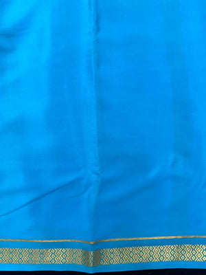 Woman wearing a Pure Mysore Crepe Silk Saree with lustrous sheen and elegant zari border, perfect for weddings and festive occasions.