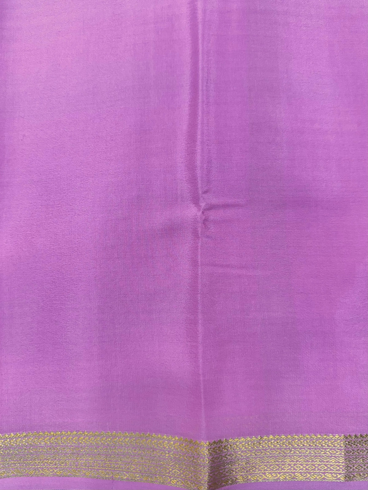 Woman wearing a Pure Mysore Silk Saree with smooth drape and zari border, perfect for weddings and traditional South Indian events.
