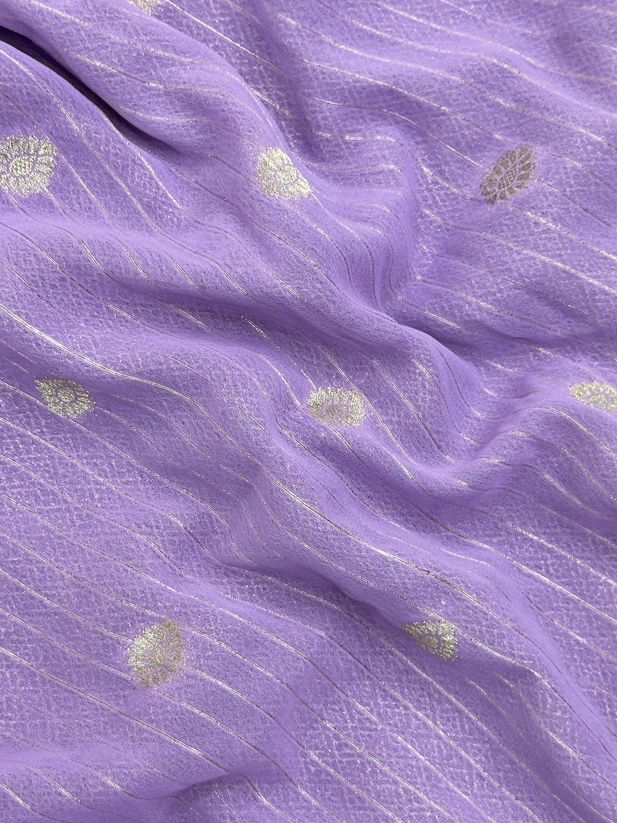 “Woman draped in a Semi Khaddi Georgette saree featuring intricate Banarasi motifs and a soft, flowy texture—perfect blend of tradition and lightness.”