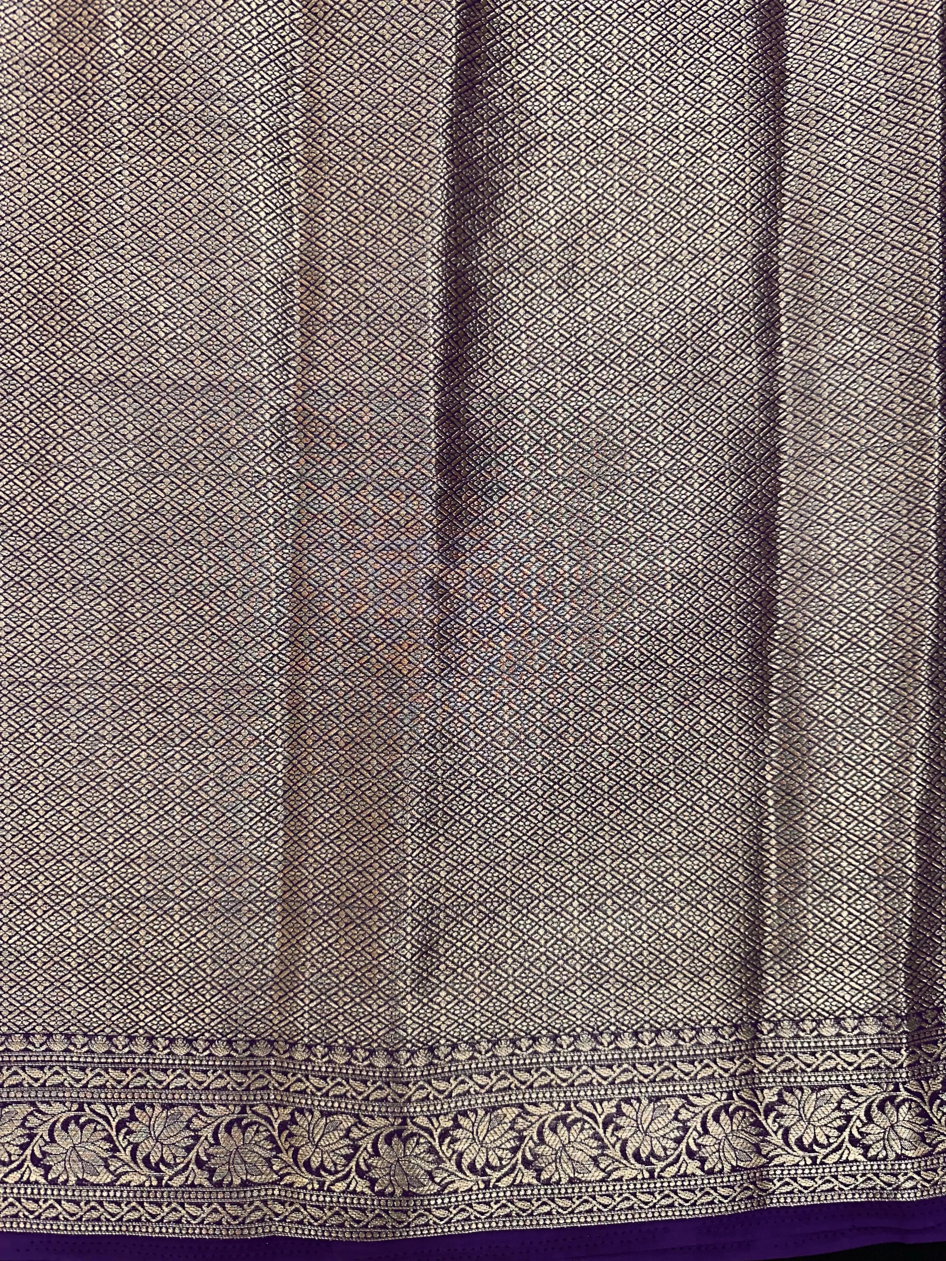 “Woman draped in a Semi Khaddi Georgette saree featuring intricate Banarasi motifs and a soft, flowy texture—perfect blend of tradition and lightness.”